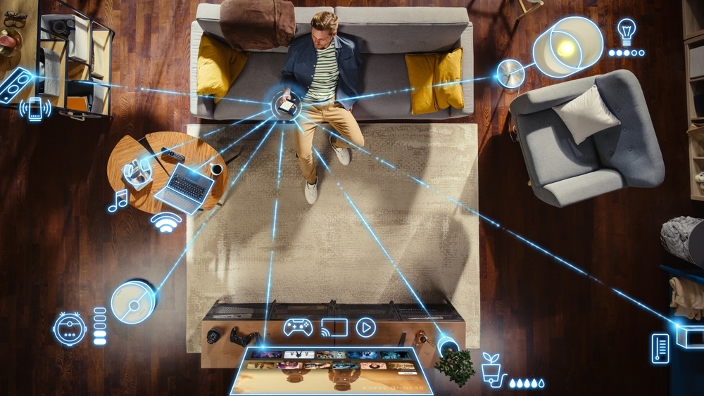 Man Sitting Down on The Couch and Connecting Smartphone to Convenient Smart Home System