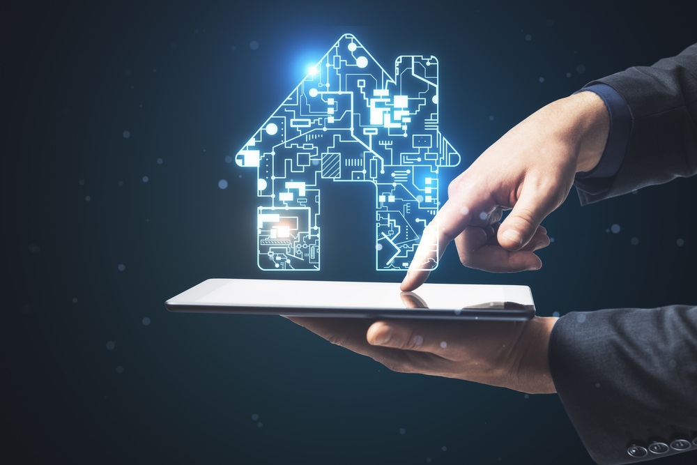 Businessman using tablet with digital circuit house hologram