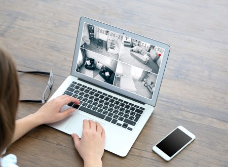 Woman using laptop at the table to check Home security