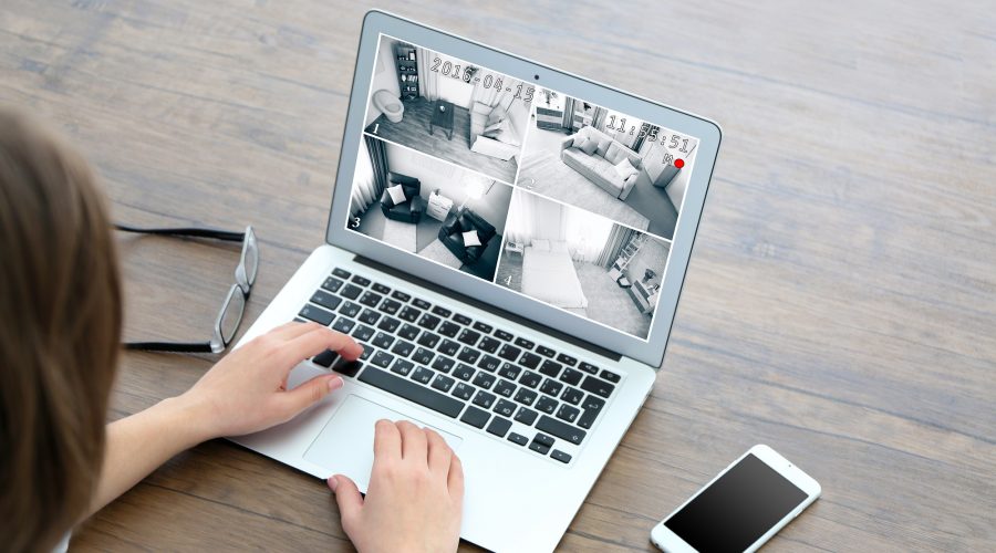 Woman using laptop at the table to check Home security