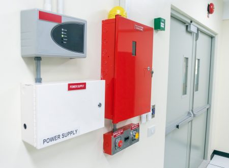 bright red fire alarm system and power supply mounted on the wall