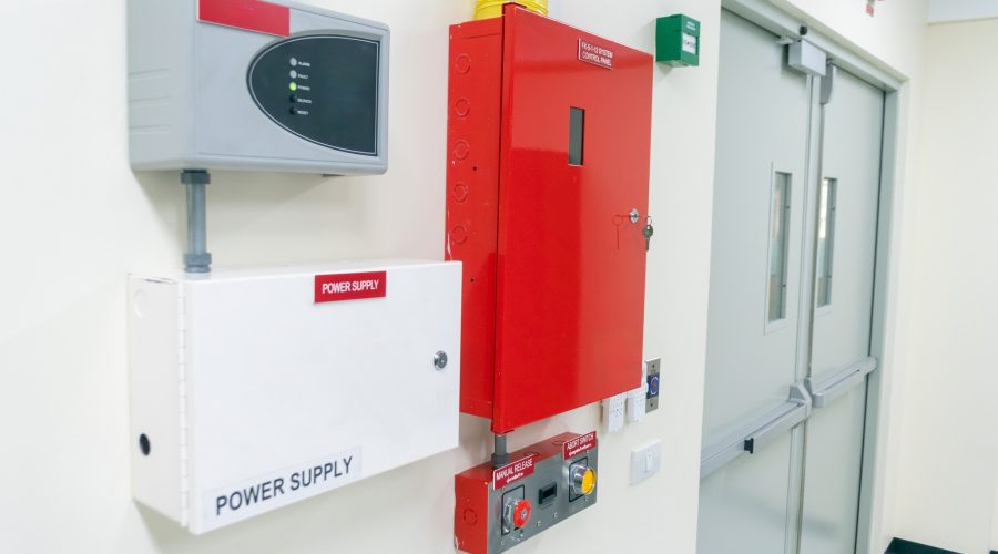 bright red fire alarm system and power supply mounted on the wall