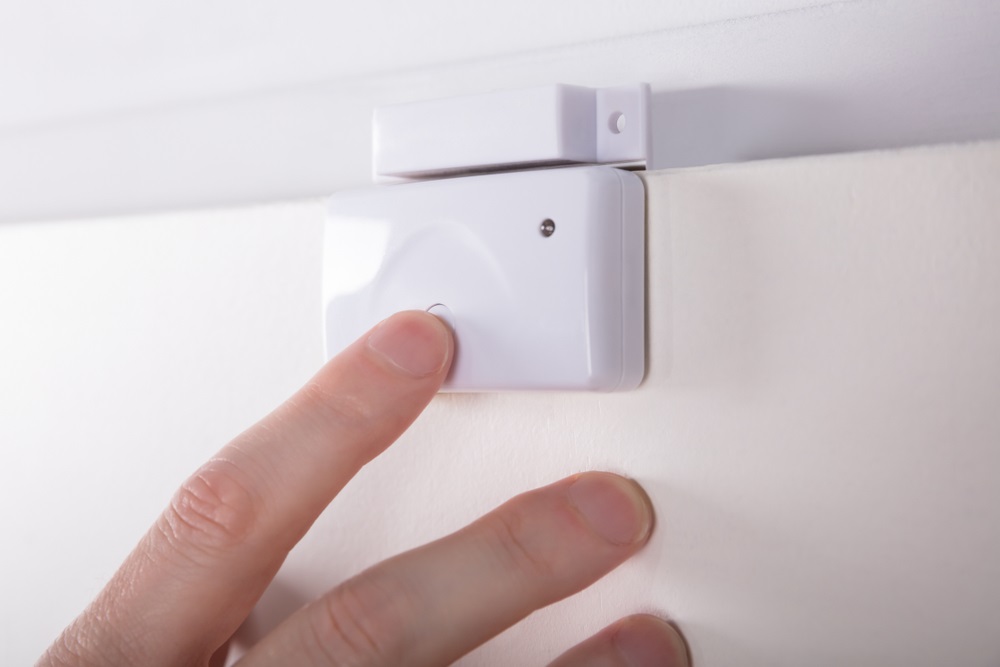 Close-up Of A Technician's Hand Fixing Security System Door Sensor