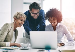 Happy Employees looking at laptop screen.