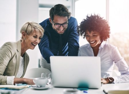 Happy Employees looking at laptop screen.