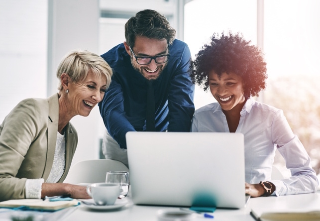 Happy Employees looking at laptop screen.